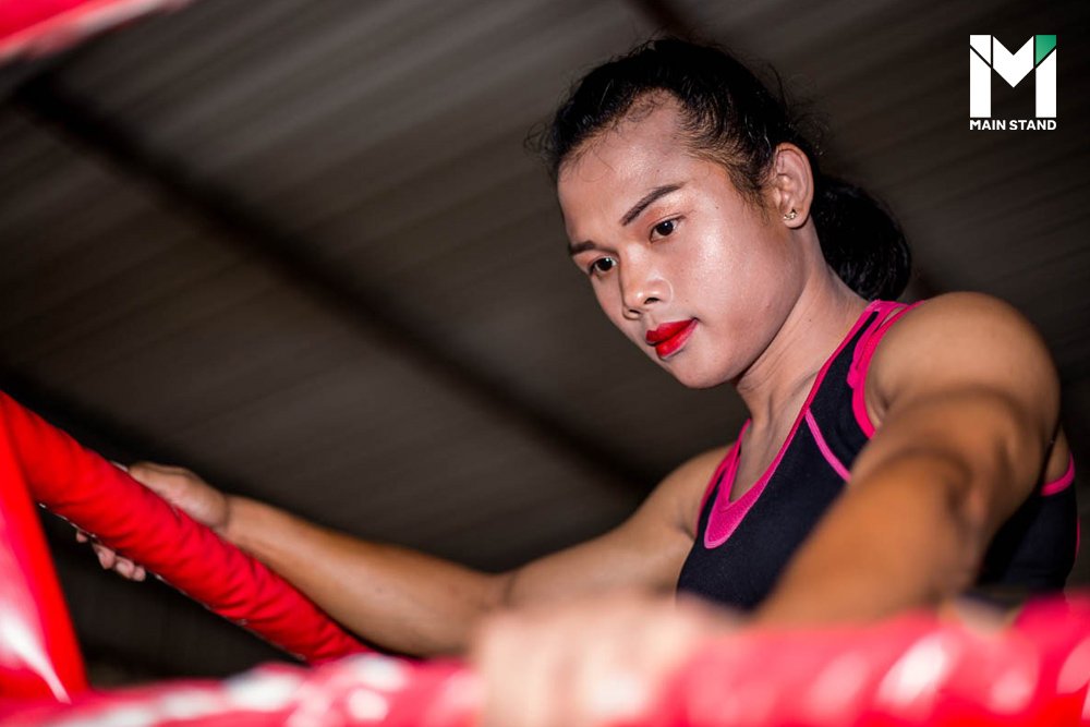 Young pretty boxer woman standing on ring. Full body portrait of